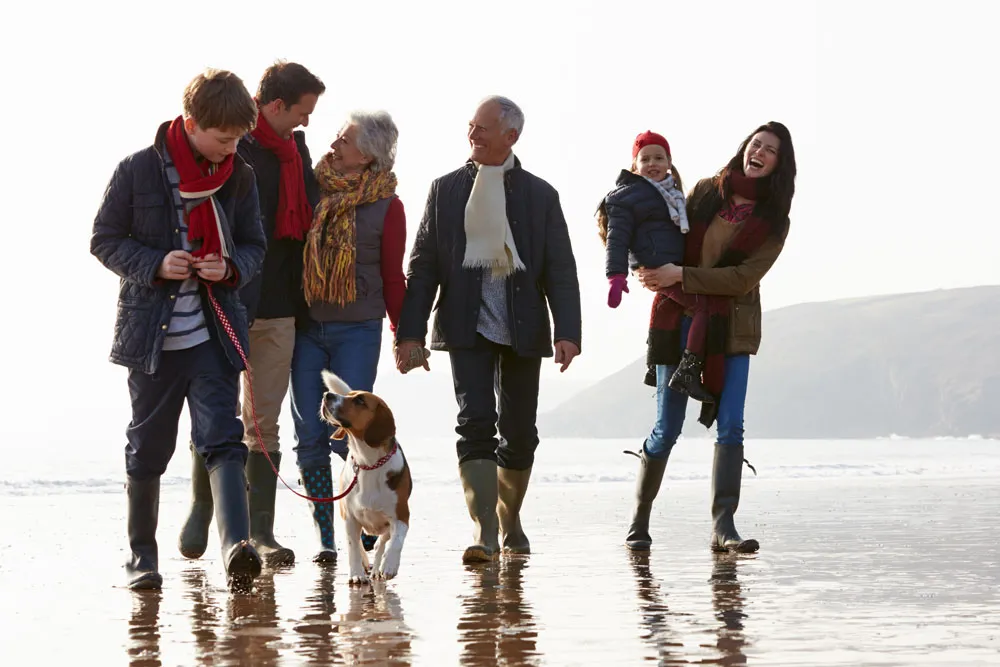 Multi-generation family walking their dog along the Somerset coast near Berrow and Brean