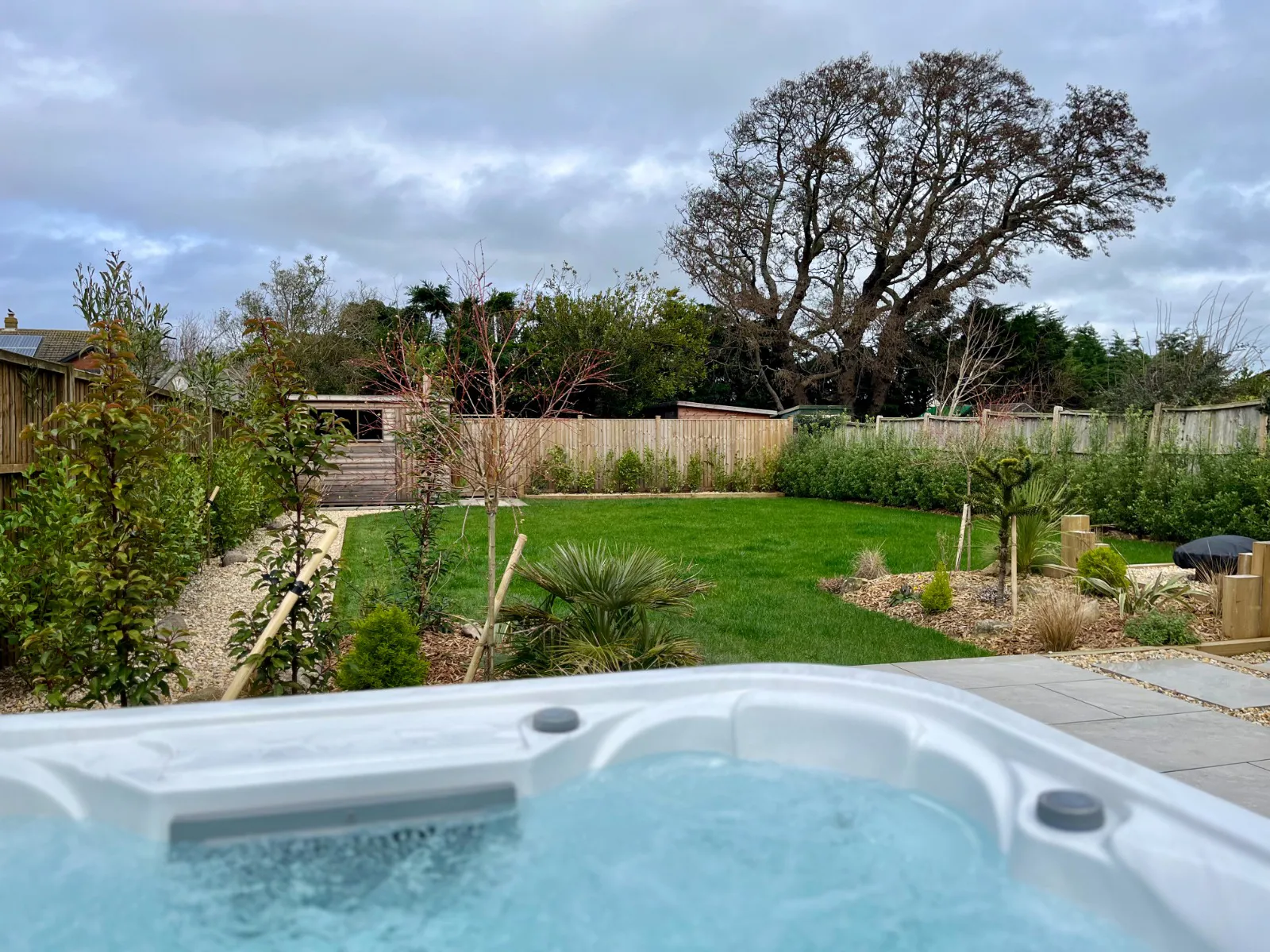 View across the garden at High Beach in Berrow showing the hot tub, new gravel pathway and privacy hedging