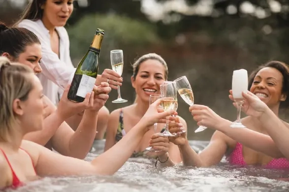Friends enjoying a hot tub together during an autumn coastal break in Somerset