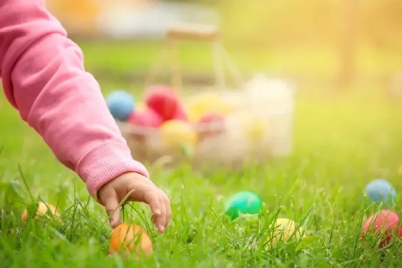 Child collecting Easter eggs during a spring family break on the Somerset coast